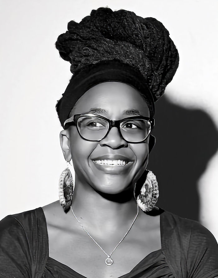 Portrait en noir et blanc d'une femme noire à lunettes souriante