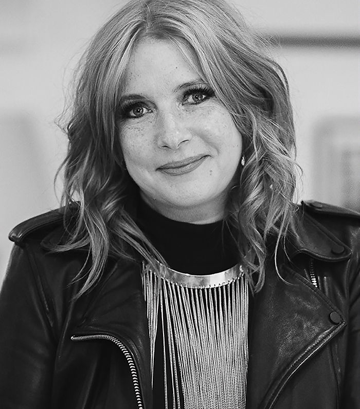 Portrait en noir et blanc, d'une femme blanche et blonde souriante